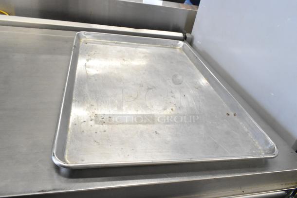 42 metal full-size baking pans in used condition. Visible wear and minor marks. Includes 42 pans per bid.