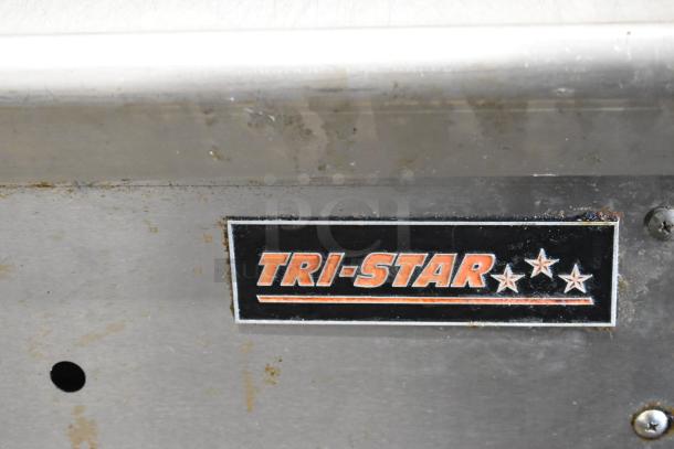 Tri-Star stainless steel commercial flat top griddle, mounted on equipment stand, displaying Tri-Star logo, slight wear visible.