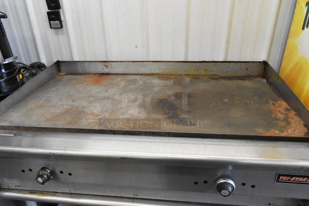 Tri-Star stainless steel commercial countertop flat top griddle on equipment stand, showing wear and surface rust.