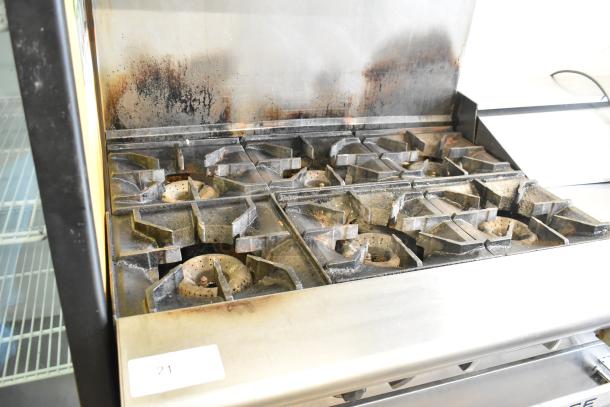 American Range stainless steel commercial 6 burner gas range with salamander cheese melter, oven, and backsplash. Used condition.