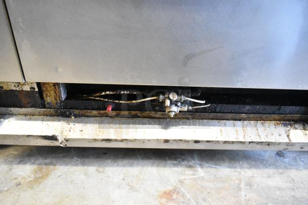 American Range stainless steel commercial gas 6 burner range with salamander cheese melter, backsplash, and oven, showing wear.