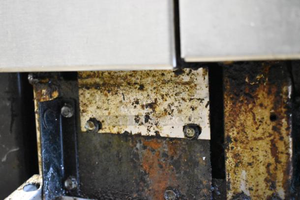 Rusty section of an American Range commercial gas range, highlighting the wear and condition.