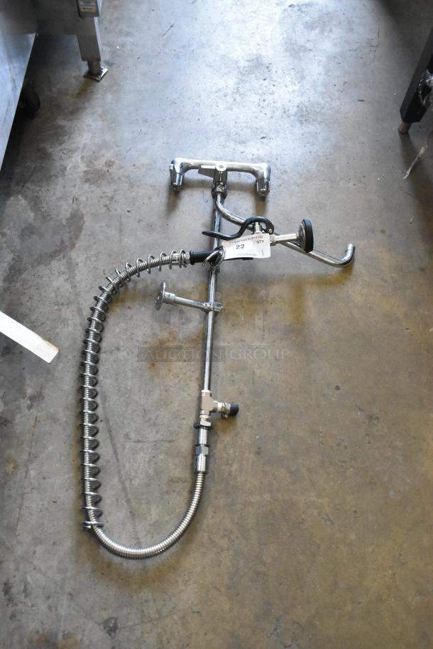 Spray nozzle attachment with faucet, chrome finish, flexible hose, some wear. Tag indicates quantity 22, FC Auctions.