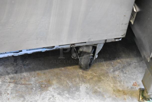 Beverage Air SPE48HC-08 stainless steel prep table with commercial casters, 115V, 1 phase, shown on storage floor.