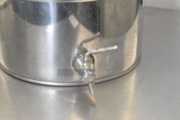 Stainless steel urn with a spigot, polished finish, ideal for beverage dispensing. Visible wear marks on the surface.