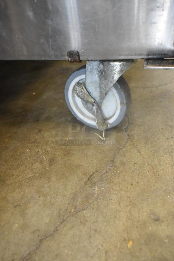 Vulcan stainless steel braising pan on casters, showing one commercial caster and base corner detail.