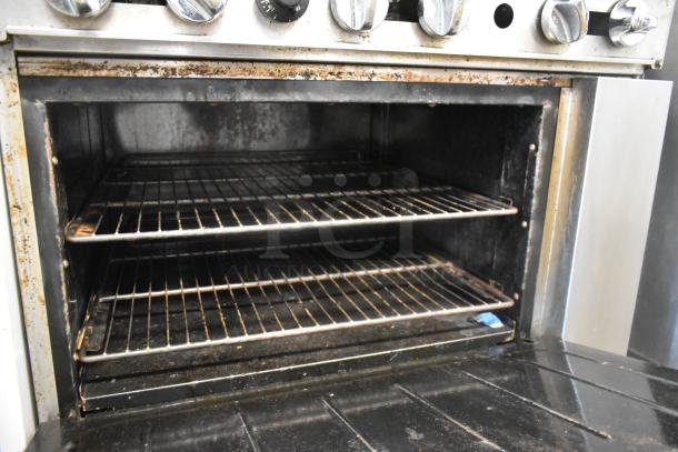 Cookrite stainless steel commercial gas range with 6 burners, oven, overshelf, backsplash, and casters. Used condition.