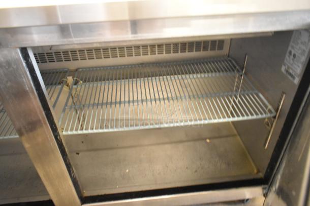 Dukers DSP60 stainless steel commercial prep table, mega top. Features interior shelf, casters, 115V, 1 phase. Good condition.