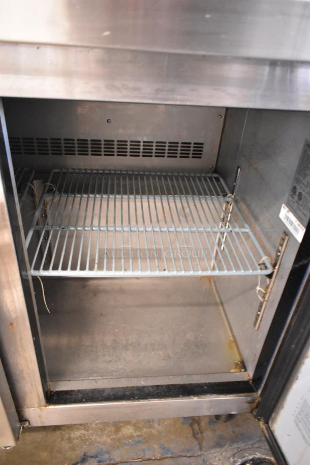 Dukers DSP72 stainless steel prep table interior; features wire shelf, visible wear, commercial casters, 115V.