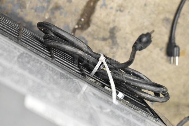 Coiled power cord for Dukers DSP72 Commercial Prep Table, showing plug and cable management on a commercial floor setting.