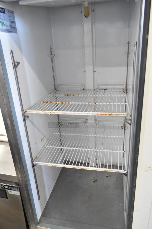 Polar GE004 stainless steel commercial cooler with poly-coated racks on casters. Signs of wear visible inside. Model: GE004.