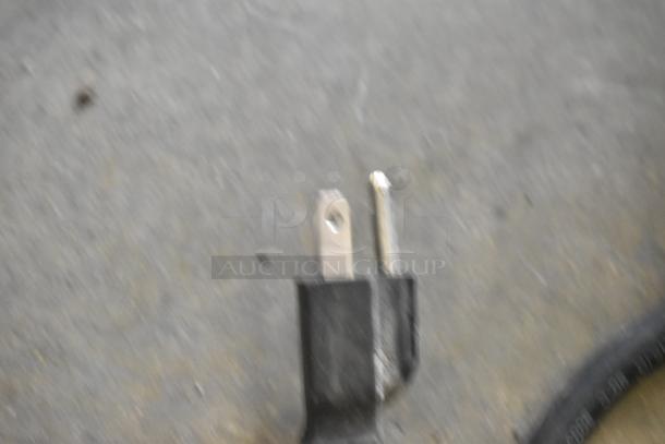 Blurry close-up image showing a power plug of the 00925E-073 Metal Commercial Countertop Merchandiser, 120 volts, 1 phase.