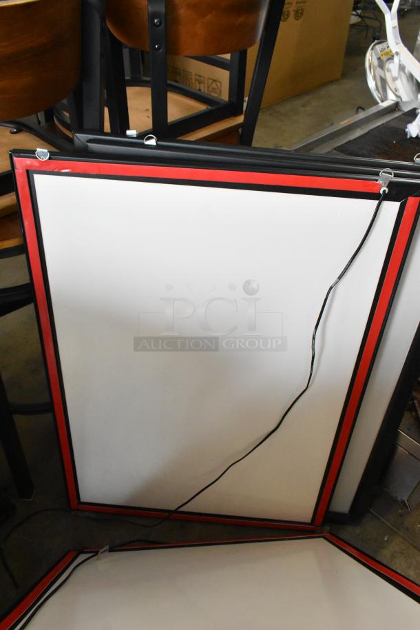 Four framed menu boards with red and black borders, featuring hanging hooks and attached power cords, shown stacked.