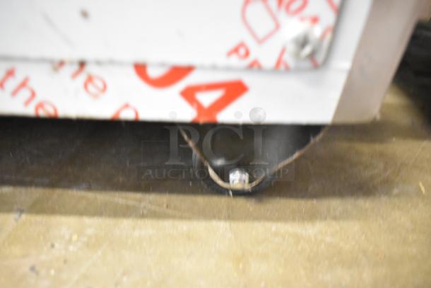 Stainless steel commercial unit on casters with MNMRV40 gear reducer, visible text and hardware details.