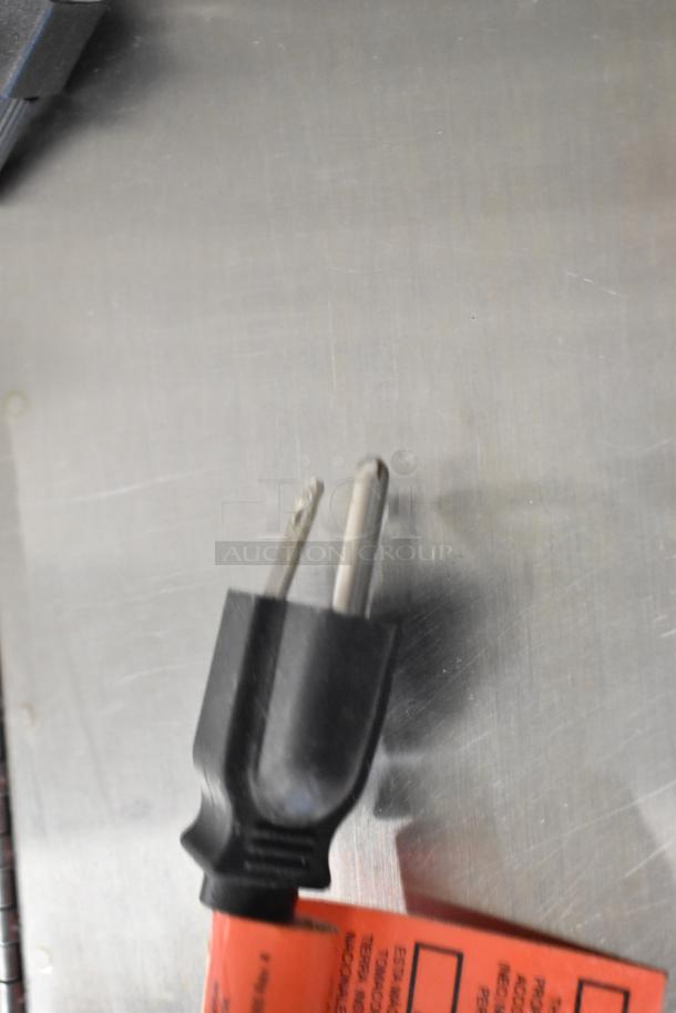 Electrical plug and safety tag detail for Taylor X83684-12 frozen drink mixer, showing standard plug and inspection marking.