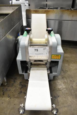 Metal commercial countertop sheeter with a white conveyor belt, used condition, auction tag #75 from PCIAuctions.com visible.