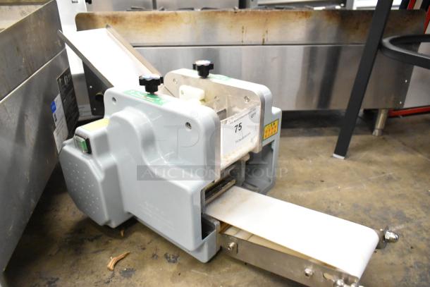 Metal commercial countertop sheeter in used condition. Features adjustable knobs, conveyor belt, and auction tag number 75.