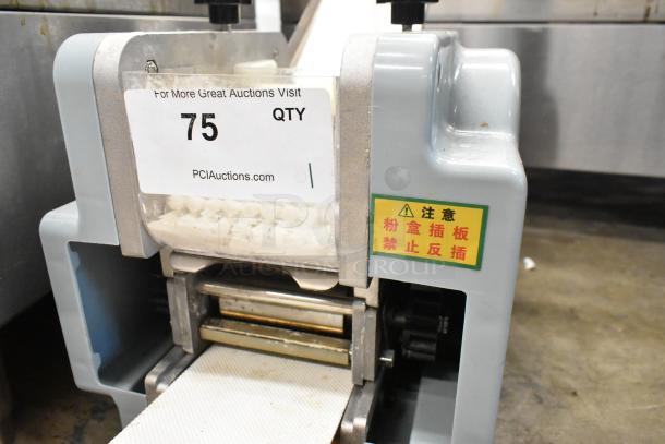 Metal commercial countertop sheeter, gray finish, visible label with auction info, caution sticker, used condition.