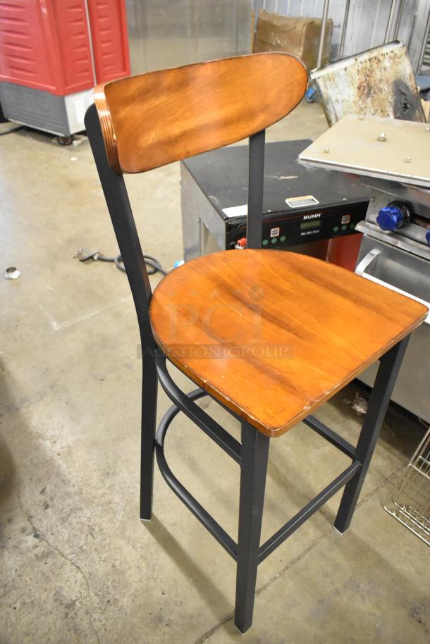 Black metal bar-height chair with wooden backrest and seat, sturdy design, excellent condition.