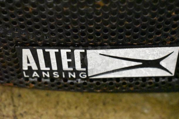 Altec Lansing IMT7002-BLK-FR trolley speaker, close-up of logo on black mesh grille.