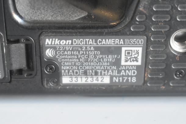 Close-up of Nikon D3500 camera label showing model details, 7.2/9V, 2.5A, and manufacturing info. Includes FCC and IC numbers.