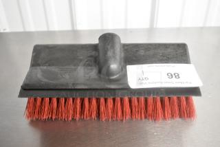 Brand new scratch and dent red-bristled broom head with black plastic base, slight blemishes visible, auction tag reads "QTY 1 86".