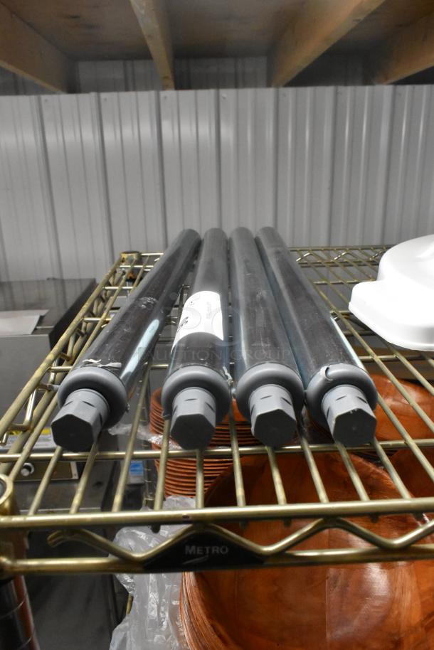 Lot of 4 brand new metal legs, scratch and dent, on a shelf. Each leg has gray caps and visible surface marks.