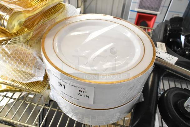 Brand new lot of paper plates with gold trim and matching plasticware. Item tag indicates quantity of 14.