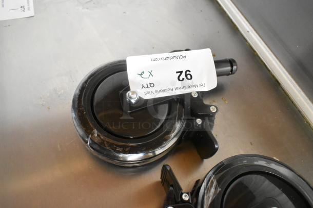 Lot of 2 new commercial casters with minor scratches. Black wheels, with attached QR code and label marked "Qty 92."