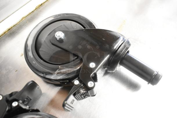 Lot of 2 commercial casters, brand new with scratch and dent imperfections, black finish, sturdy construction, visible locking mechanism.