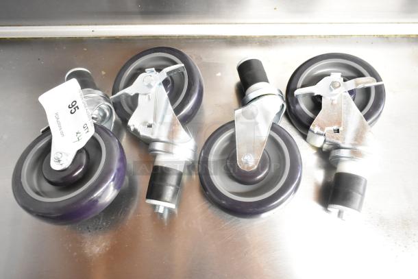 Lot of 4 new commercial casters, scratch and dent condition. Each caster features a purple wheel and metal swivel bracket.
