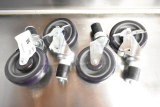 Lot of 4 new commercial casters, scratch and dent condition. Each caster features a purple wheel and metal swivel bracket.