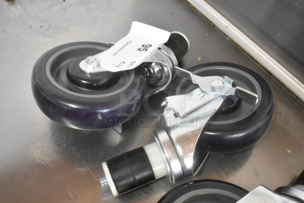 Lot of 4 brand new commercial casters, scratch and dent condition, with locking mechanism and purple wheels, tag visible.