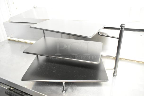 Brand new 3-tier rack, slight scratches, black finish, metal frame. Ideal for display or storage.