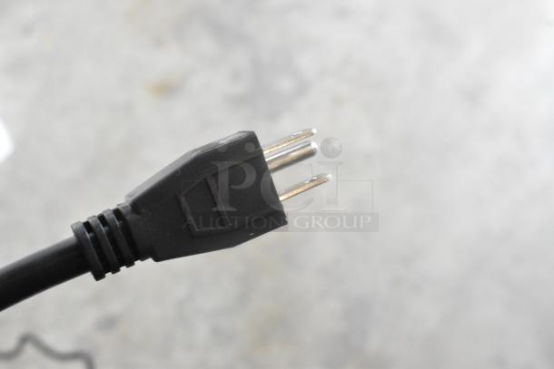 Close-up of an electrical plug, part of a Lavex hand dryer. The image focuses on the plug's prongs.