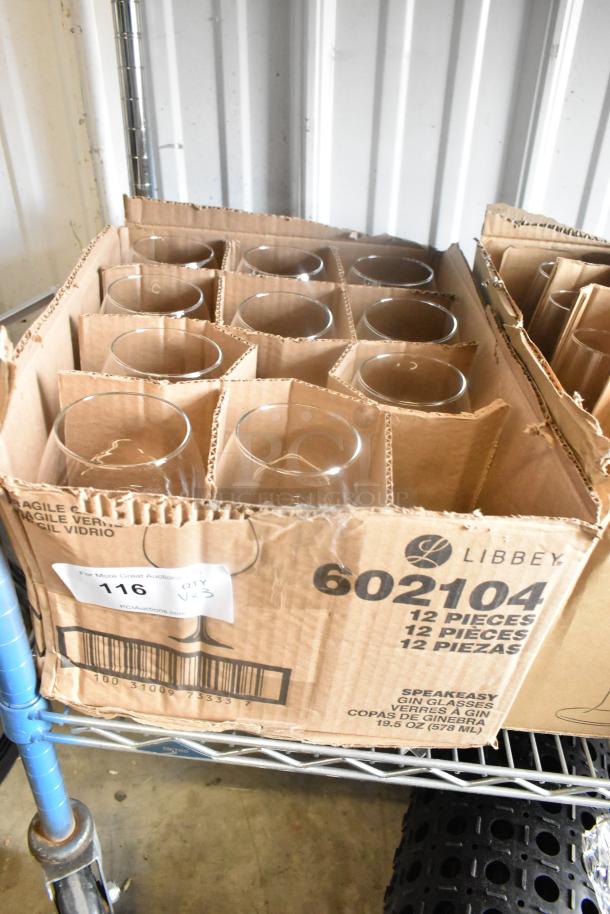 Box of 12 new Libbey 602104 Speakeasy 19.5 oz. gin glasses in original packaging, marked for auction.