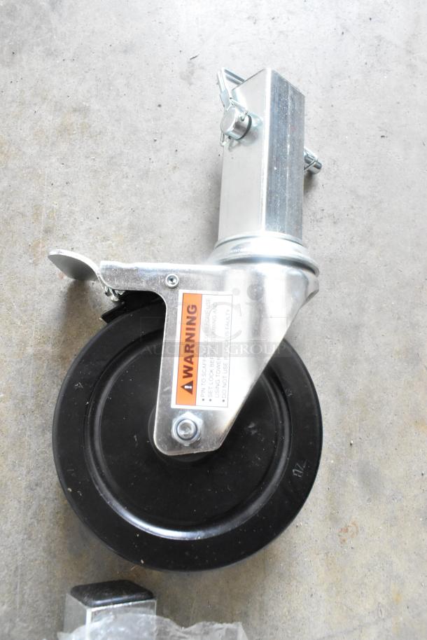 Brand new commercial caster with metal frame, black wheel, and warning label. Features lock and slight scratch. Lot of 4.
