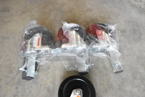 Lot of 4 brand new commercial casters, partially wrapped, minor scratches. Includes warning labels, metal and rubber components.