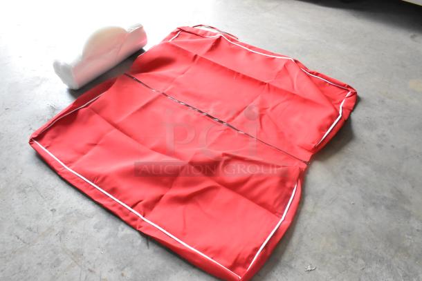 Brand new red bag and white unit, showing minor scratches and dents, unfolded on a concrete surface.