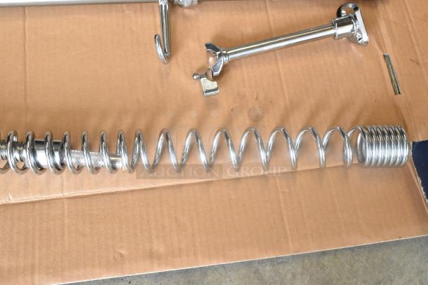 BRAND NEW SCRATCH AND DENT! 750PRAXF Waterloo 1.15 GPM pre-rinse assembly showing riser, hose, and spray valve on cardboard.