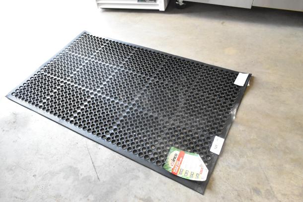 BRAND NEW Winco RBM-35K black anti-fatigue floor mat, scratch and dent, with visible tag indicating model and features.