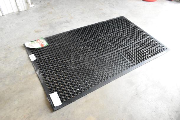 Black Winco RBM-35K anti-fatigue floor mat, brand new with minor scratches, features honeycomb pattern for comfort. Tags intact.
