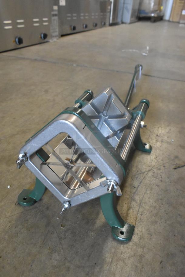 Brand new Garde metal vegetable cutter, scratch and dent condition, with green and metallic frame on concrete floor.
