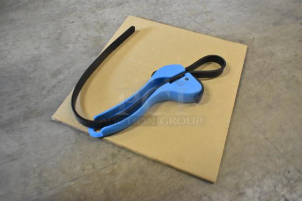 Blue tool with a black strap on a cardboard surface. Identified as a Zurn ZERK-TM Sensor Retrofit Kit, new with scratches.