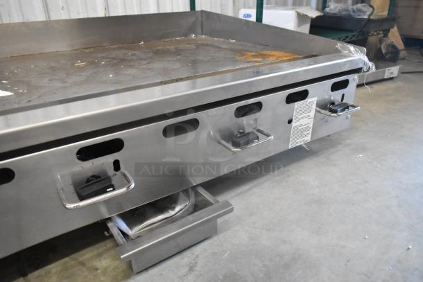 Wolf AGM60-101 stainless steel flat top griddle, 135,000 BTU, natural gas, good condition, visible control knobs.