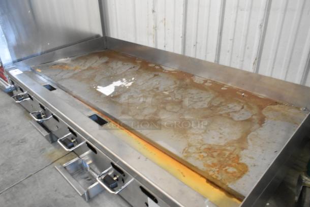 Wolf AGM60-101 stainless steel commercial griddle, natural gas, 135,000 BTU, flat top, noticeable wear, with control knobs.