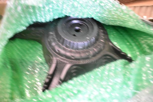 Blurred image of a metal tabletop base wrapped in green bubble wrap, part of a set of 11 scratch and dent items.