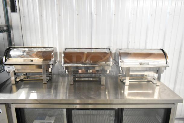 Three brand new stainless steel chafers, minor scratches and dents, reflective finish, sturdy frame, auction lot number visible.