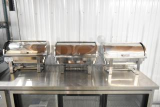 Three brand new stainless steel chafers, minor scratches and dents, reflective finish, sturdy frame, auction lot number visible.