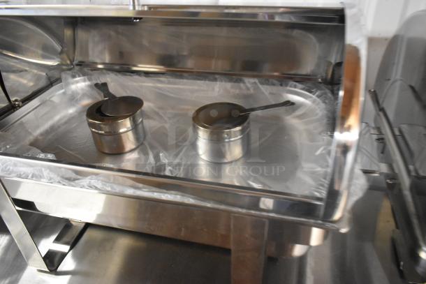 Brand new stainless steel chafer with minor scratches and dents, includes serving utensils, durable and versatile.